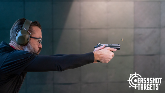 man with ear muffs aiming gun at shooting targets