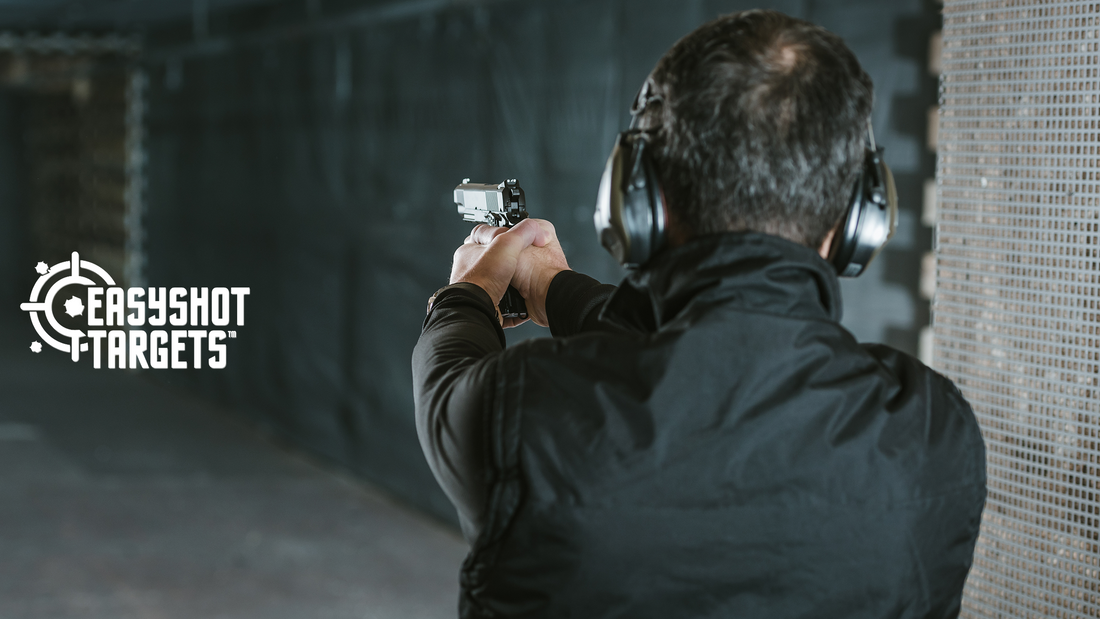 man with safety equipment aiming gun at shooting range