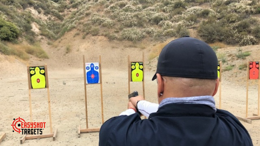 A man at an outside shooting range, shooting at EasyShot silhouette targets