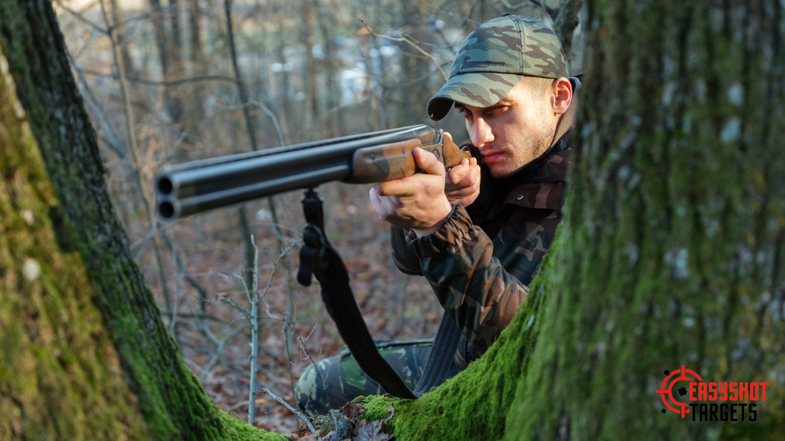 A man standing behind a tree pointing a shotgun