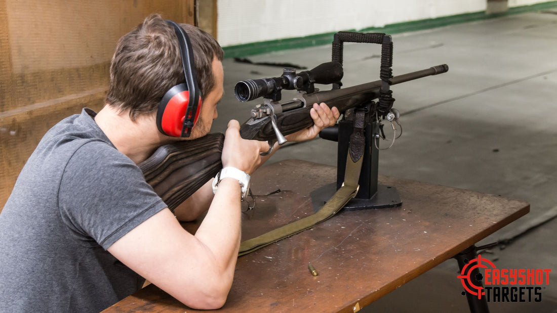 A person wearing earmuffs and pointing his rifle to a target