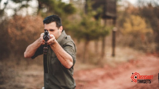 A man aiming his rifle with a forest in the background